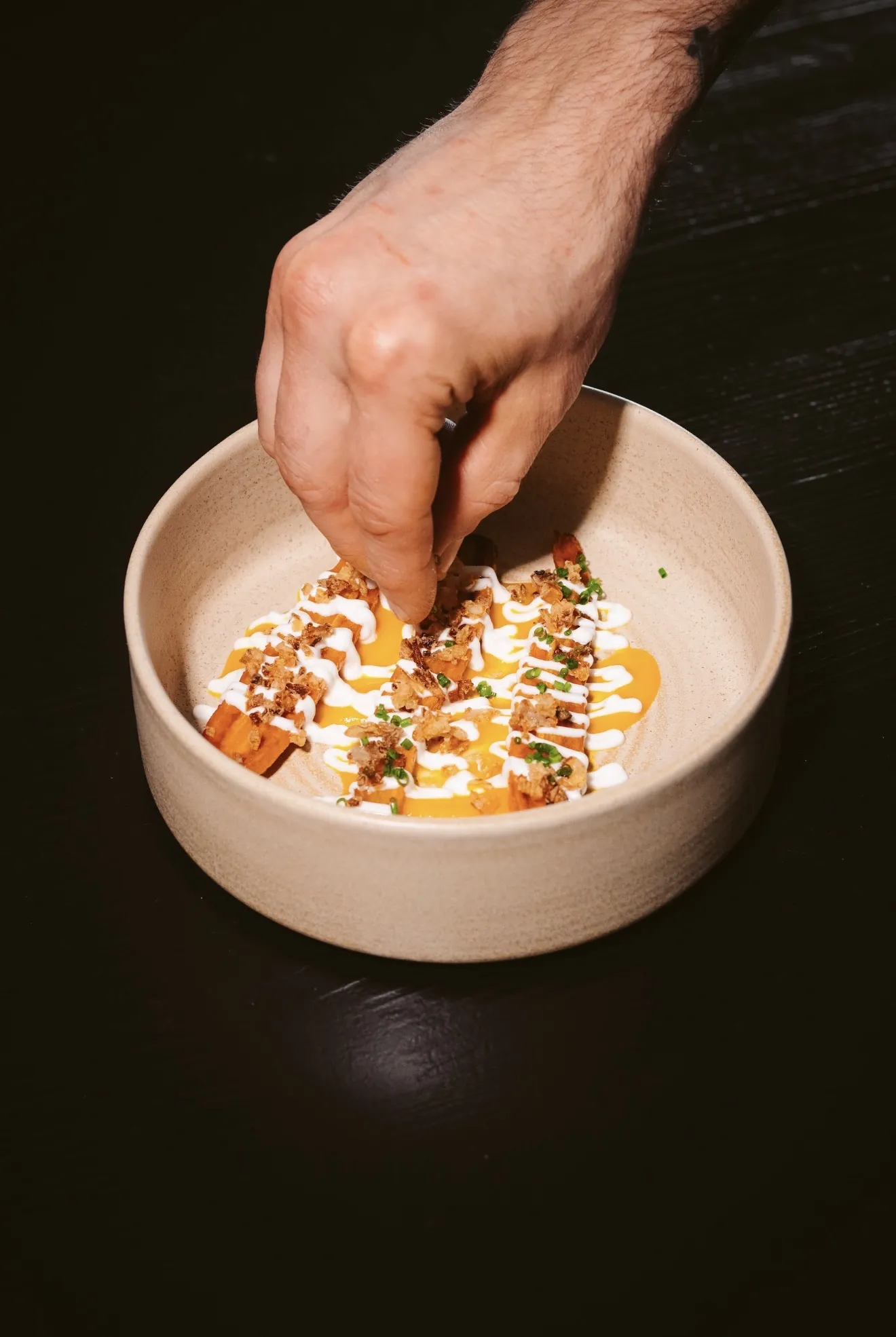 Chef finishing a plated dish